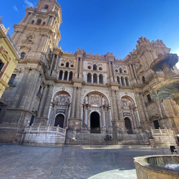 a large building with a fountain in front in Malaga