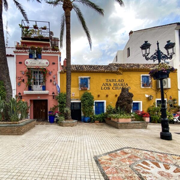 a building with palm trees and a street light in Marbella